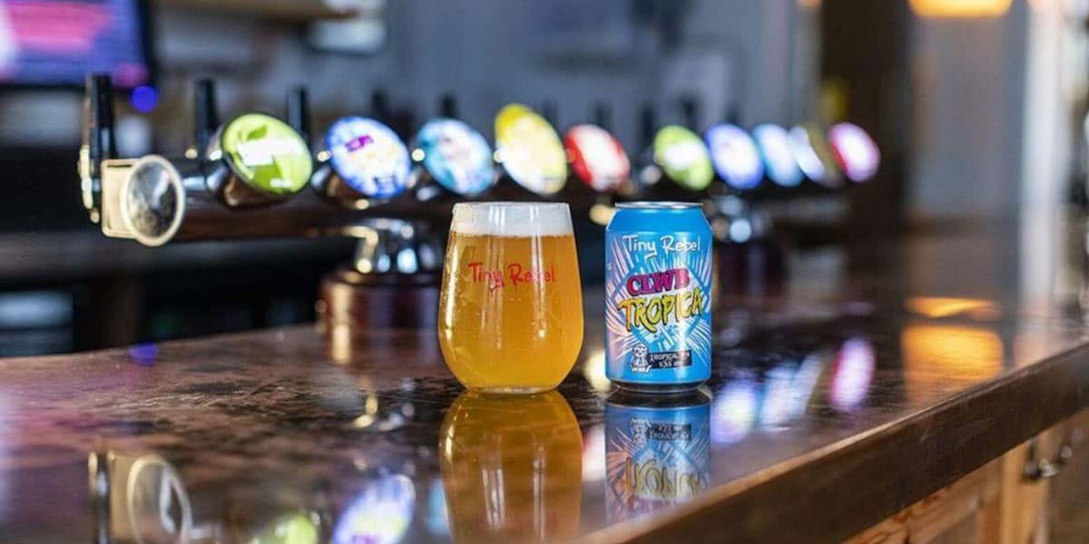 Glass and can of Tiny Rebel Clwb Tropicana on a bar